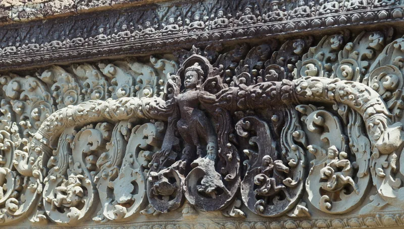 Intricate sandstone carvings depict a deity and floral motifs on a lintel at Angkor's Pre Rup temple in Siem Reap.