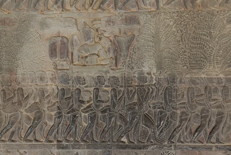 Ancient stone bas-relief carving depicting a royal procession with soldiers at Angkor Wat, Siem Reap.