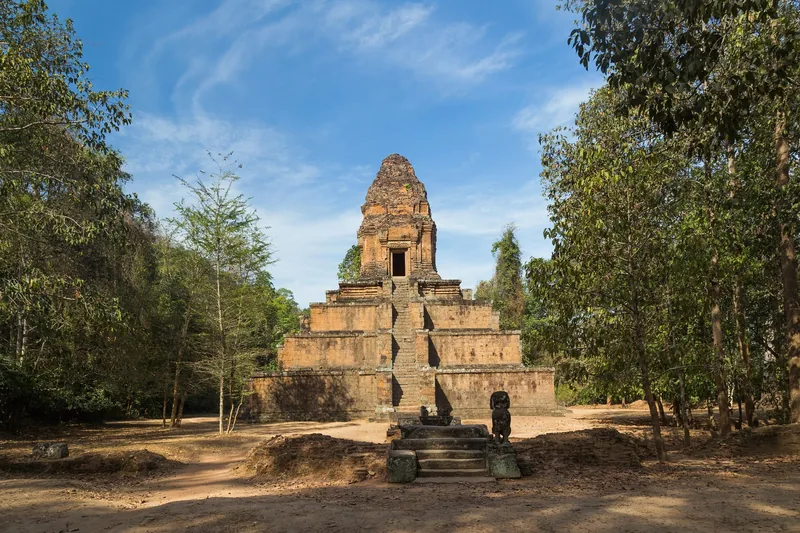 A brick pyramid temple tower rises among trees at Angkor's Baksei Chamkrong in Siem Reap.