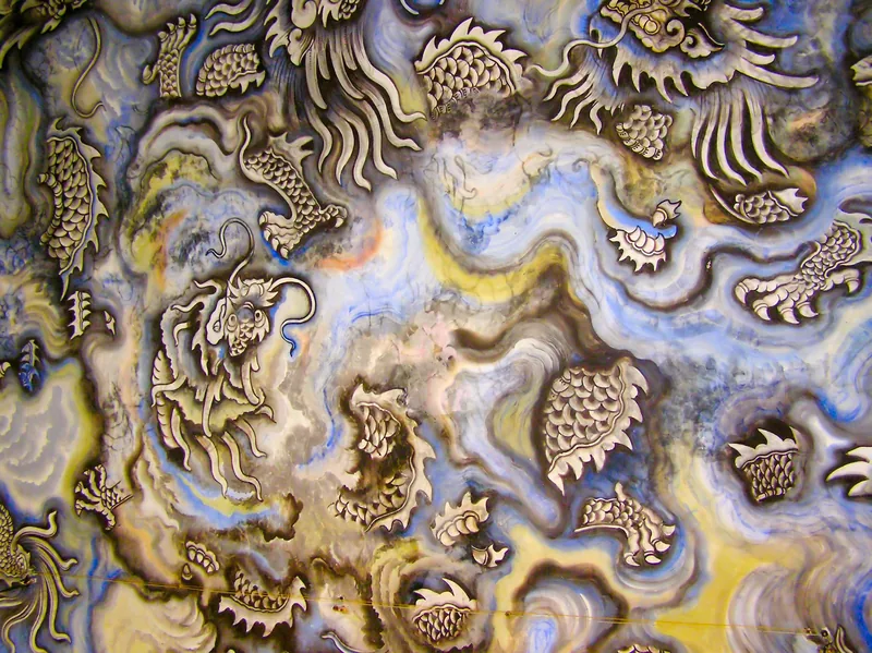 Intricate mosaic artwork with dragon motifs in swirling glazed ceramic colors at Khai Dinh Tomb in Hue.